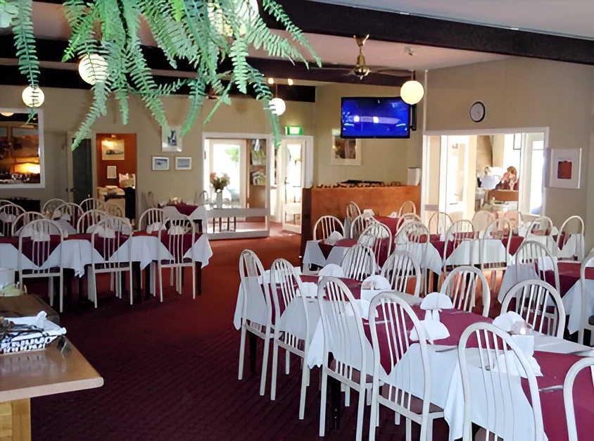 Tables set with white cloths and burgundy napkins at Prospectors Restaurant